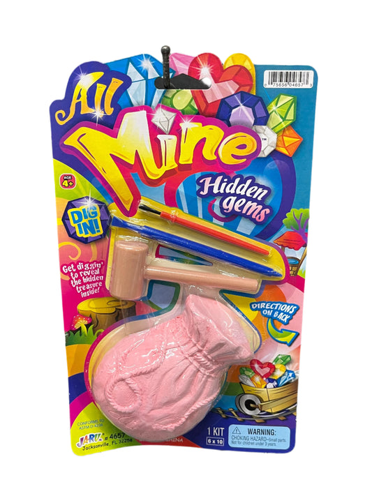Packaged toy with pink object and colorful 'All Mine Hidden Gems' branding.